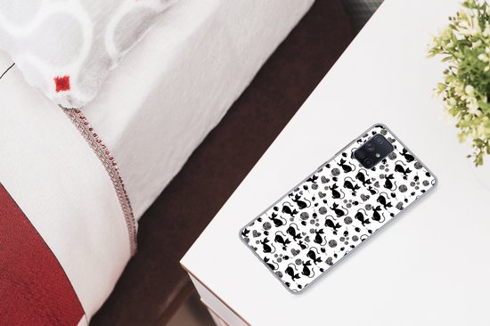 Coque transparente avec des chats noirs et blancs et des pelotes de laine, sur une table de chevet.