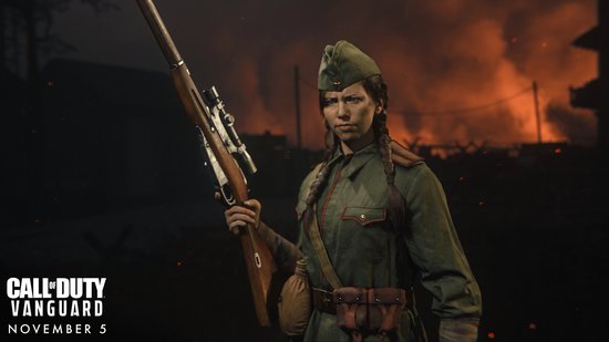 Soldate met groen uniform, groene pet en geweer, gevlochten haar, met brandende achtergrond.