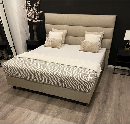 Beige boxspring 180x200cm met geometrisch patroon deken in beige en grijs. Hoge, gestoffeerde hoofdbord.