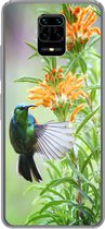 Geschikt voor Xiaomi Redmi Note 10 Lite hoesje - Close-up van een kleurrijke vogel naast planten met oranje bloemen - Siliconen Telefoonhoesje