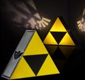 Twee donkere driehoekige lampen; één met zilveren Hylian crest, de ander met gele/zwarte Triforce.