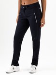 Model in donkerblauwe sportbroek met trekkoord, ritszakken en witte biezen, met witte sportschoenen.