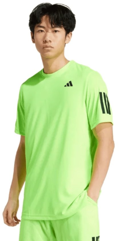 Jonge Aziatische man draagt een felgroen t-shirt met korte mouwen, zwarte Adidas strepen op de mouwen en een zwart Adidas logo op de borst.