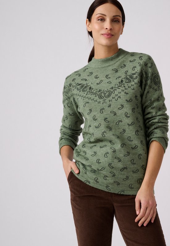 Groene trui met hoge hals en subtiele paisleypint, gedragen door een model met hand in broekzak.