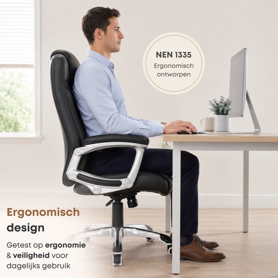 Man met blauw overhemd zittend in een zwarte ergonomische bureaustoel aan een bureau. NEN 1335 gecertificeerd.