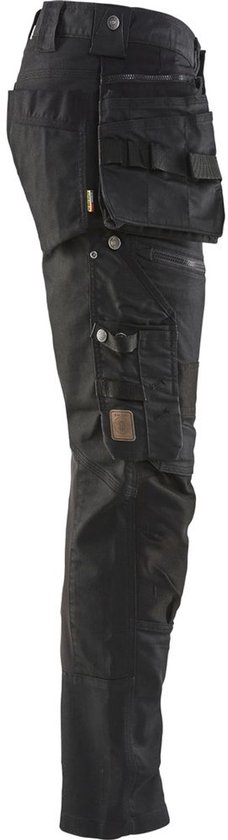 Zwarte werkbroek met zakken, riemen en knopen.
