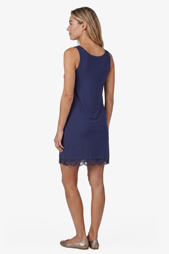 Vrouw in donkerblauwe slipdress van DIDI met kanten rand, kijkend naar de zijkant.