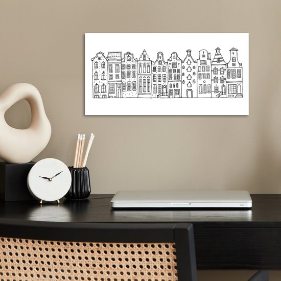 Zwart-wit poster met Amsterdamse huisjes, boven een bureau met laptop.