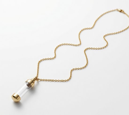 Collier doré avec un pendentif tube en verre avec des capuchons dorés, sur fond blanc.