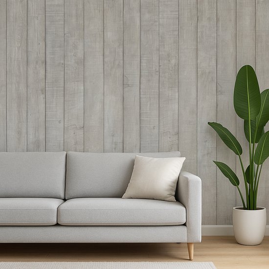 Canapé gris avec un coussin crème devant un mur de lattes de bois.