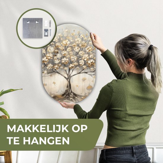 Vrouw hangt een ovaal kunstwerk van 3 mm dik kunststof met een beige, gouden en grijze boom op.