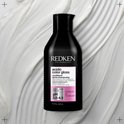 Conditionneur Redken Acidic Color Gloss. Flacon noir avec texte rose et blanc. pH 3.5-4.5.
