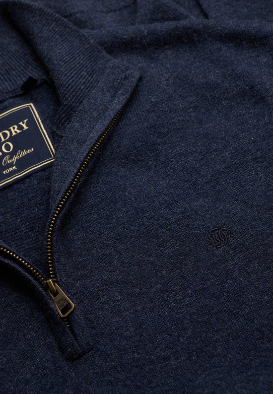 Donkerblauwe melange gebreide trui met ritssluiting en merklabel, dichtbij.