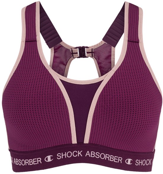 Donkerpaarse sportbeha met roze bies, perforaties en verstelbare bandjes. 'Shock Absorber' band aan de onderzijde.