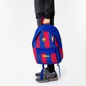 Blauwe rugzak met rode strepen, FC Barcelona logo en 'Barça' tekst, gedragen door een persoon.