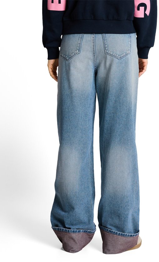 Achterkant van een wijde, lichtblauwe jeans met omgeslagen zoom.