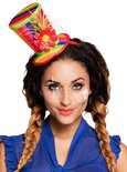 Vrouw met gevlochten haar, clownsmake-up en een veelkleurige hoed met bloem en veren.