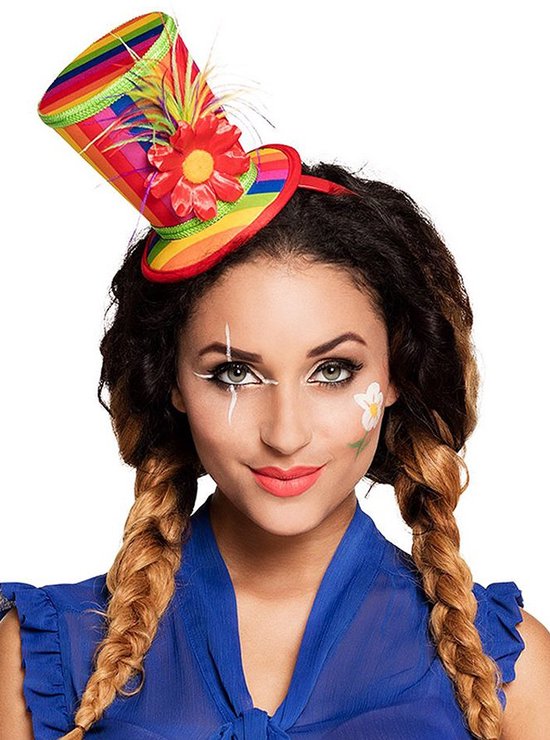 Vrouw met gevlochten haar, clownsmake-up en een veelkleurige hoed met bloem en veren.