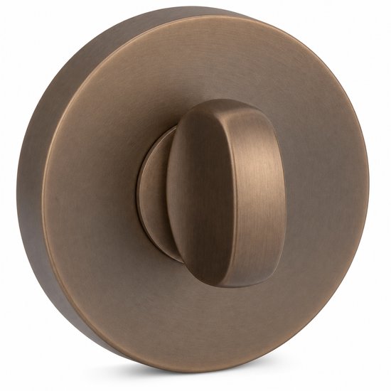 Bronzen toiletdeurslot met een draaiknop, op witte achtergrond.