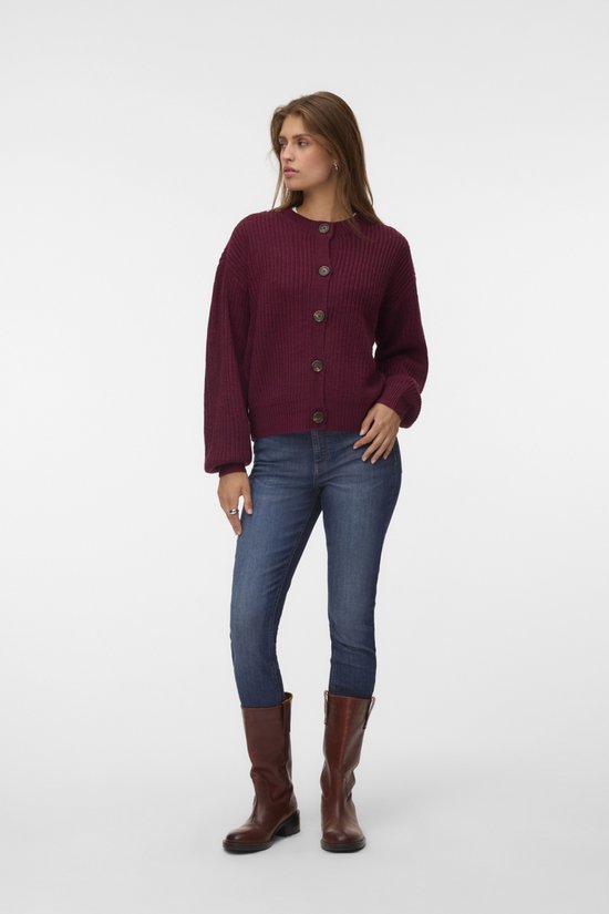 Model draagt bordeauxrode gebreide cardigan met knopen en ballonmouwen.