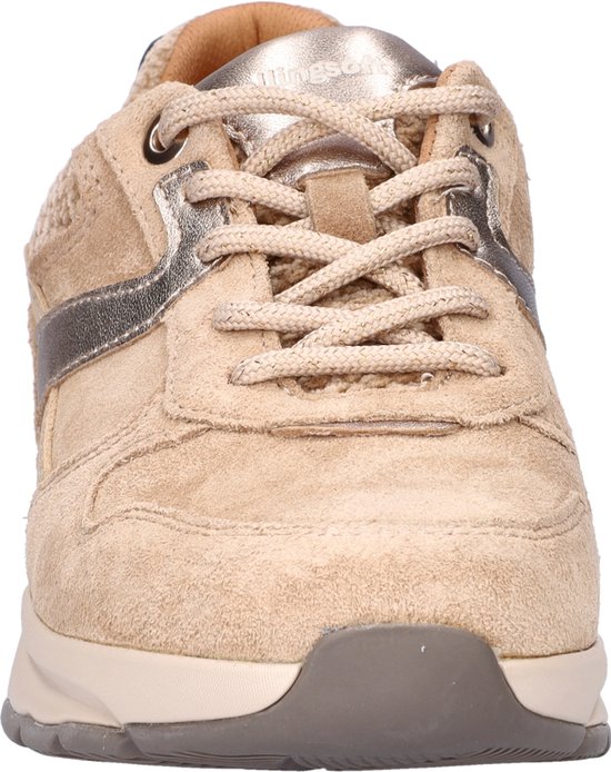 Voorkant van een lichtbruine suède sneaker met veters en zilveren detail.