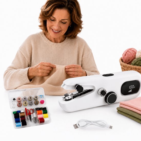 Une femme souriante coud du tissu avec une machine à coudre portable blanche, à côté d'un kit de couture et d'un panier de laine.