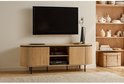 Ovalen houten tv-meubel met geribbelde deuren, open vakken en een zwarte rand. Televisie hangt erboven.