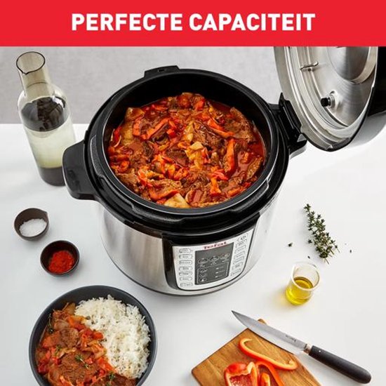 Tefal multicooker vol met stoofvlees en groenten, naast een kom rijst en ingrediënten op een tafel.