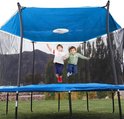Twee jongens springen op een blauwe trampoline onder een blauw zonnescherm met veiligheidsnet.