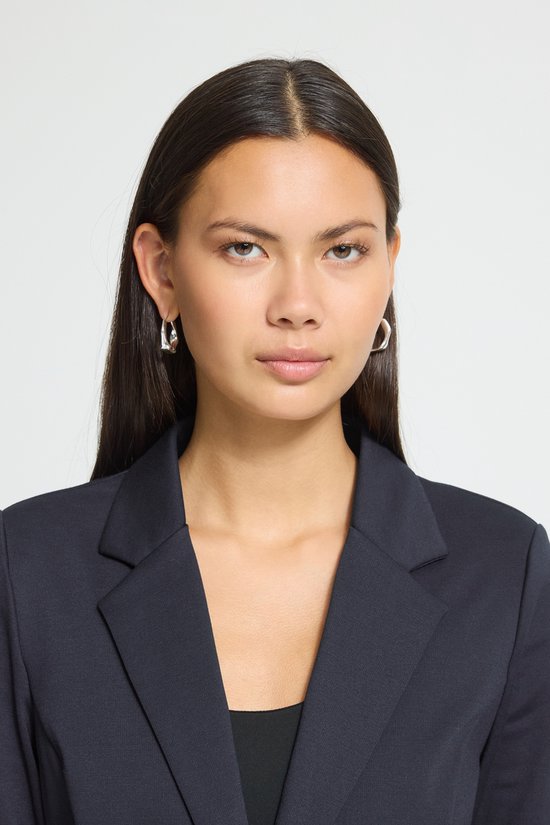 Close-up van een model met een donkerblauwe blazer.