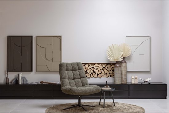 Zwart dressoir met een grijze fauteuil ervoor, decoratie en een spiegel.