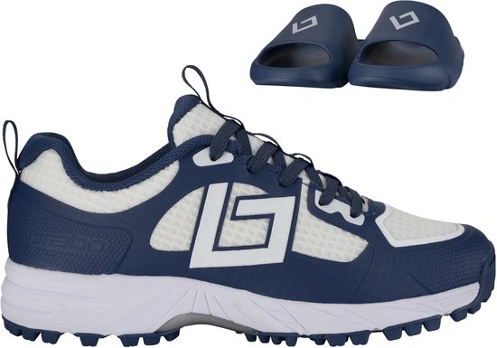 Chaussure de hockey junior bleu marine et blanc avec une paire de tongs assorties bleu marine au-dessus.