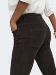Bruine ribbroek met achterzakken, gedragen door een model met een witte blouse.