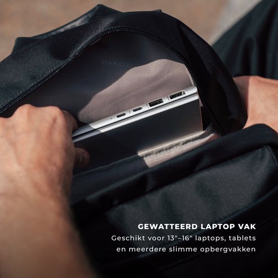 Hand past een laptop in het gewatteerde laptopvak van de rugzak.