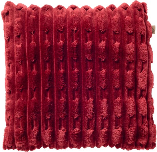 Rood fluwelen sierkussen met ribbels en ingeweven stippen. Een label is zichtbaar aan de rechterkant.