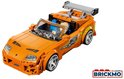 Oranje LEGO Toyota Supra MK4 met spoiler, bestuurder en groene graphics, vanuit een schuin vooraanzicht.