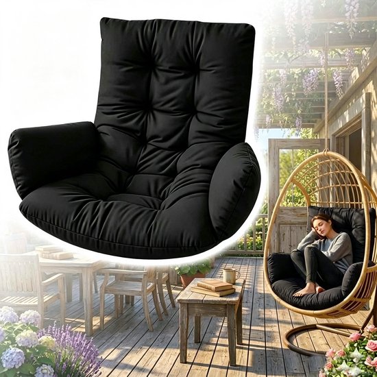 Een vrouw zit ontspannen in een schommelstoel met een zwart kussen op een houten terras met planten.