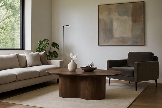 Moderne woonkamer met een lichte bank, fauteuil, en een ovale salontafel van walnoothout met decoratie.