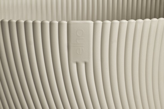 Detail van de textuur van een taupekleurige plantenpot met ribbelpatroon.