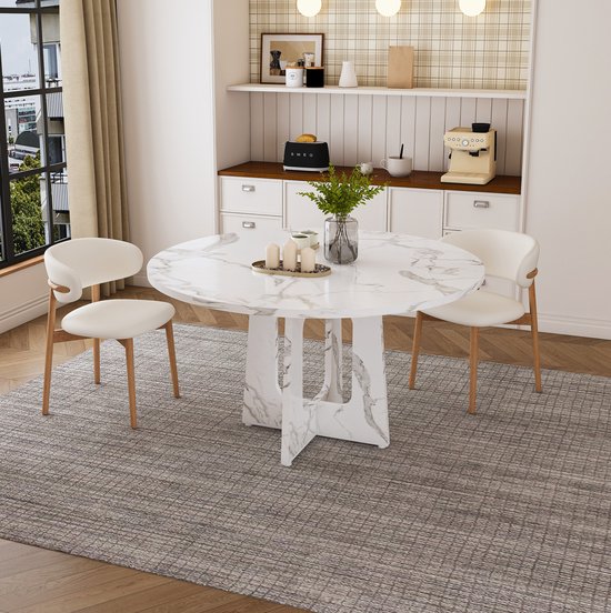 Ronde marmerlook eettafel met witte stoelen met houten poten.