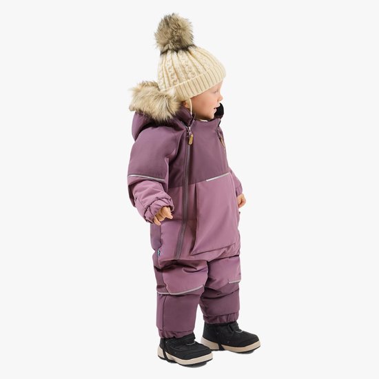 Zijaanzicht van een kind in een paarse winteroverall met ritssluiting, imitatiebont en reflecterende details.
