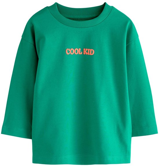 Groen T-shirt met de tekst 'COOL KID' in oranje letters op de borst.
