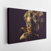 Canvas schilderij - Halloween golden woman or girl holding painted gold pumpkin has pretty face with makeup and body art metallized color with decorative flowers on head on black b
