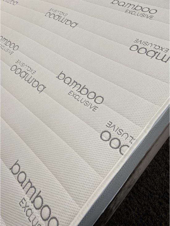 Detail van de witte matras met 'bamboo exclusive' opdruk en gestreepte textuur.
