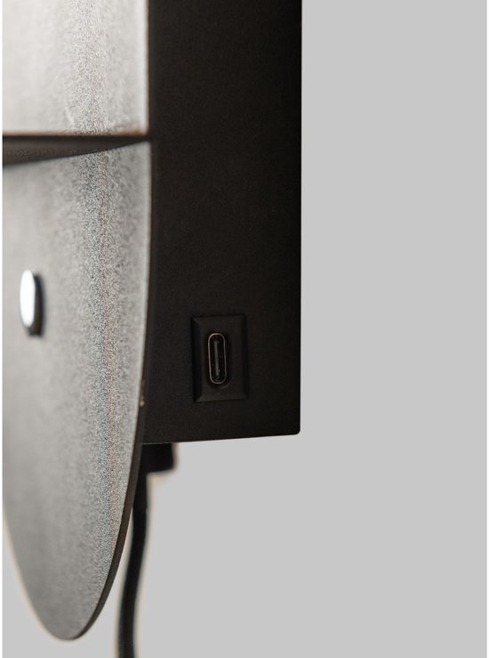 Gedetailleerde opname van de zijkant van een zwarte wandlamp die een USB-C poort toont.