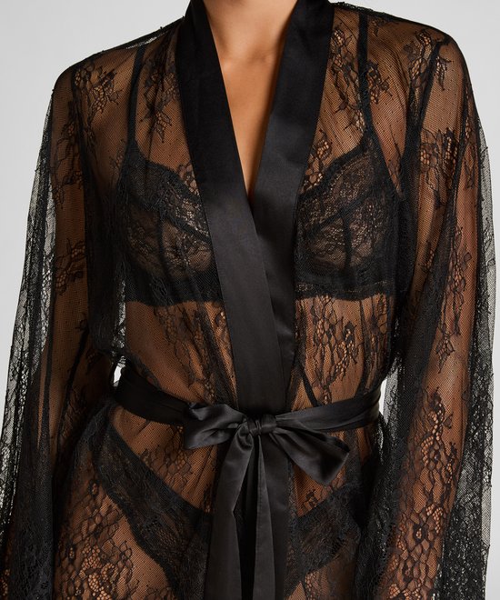 Detailopname van een zwarte kanten kimono met satijnen ceintuur en wijde mouwen.