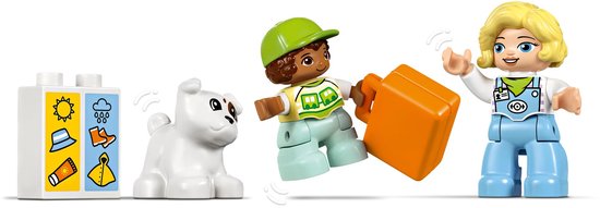 Figurines LEGO Duplo d'un chien blanc, deux enfants et une valise orange.