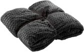 Donkergrijze, opgevouwen plaid met zigzagpatroon, vastgebonden met een lint.