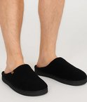 Zwarte teddy wollen herenpantoffels gedragen door een man.
