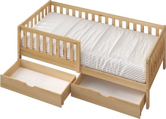 Houten ledikant met spijlen en twee open lades met gestreepte lakens.